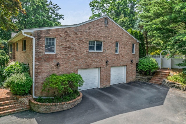 14 Etna Ln, Dix Hills, NY 11746 - view of property exterior featuring asphalt driveway, a garage, and brick siding