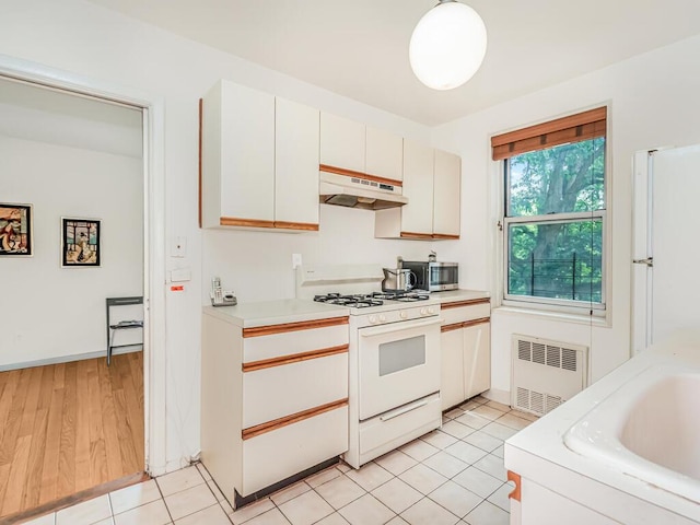 679 W 239th St W Unit 3J, Bronx, NY 10463 - kitchen with white appliances, under cabinet range hood, radiator heating unit, and light countertops