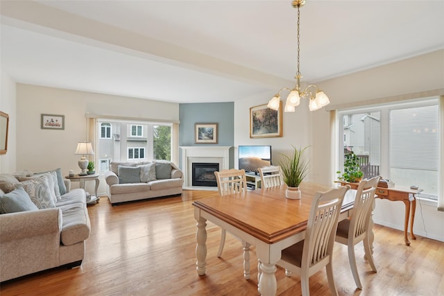 4 Cliffside Ct, Highland Mills, NY 10930 - dining area with a glass covered fireplace, light wood-style floors, and a chandelier