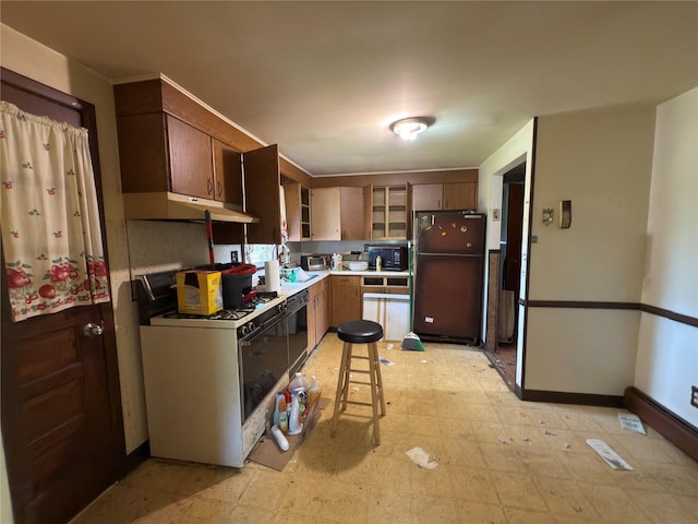 6 James Pl, Wappingers Falls, NY 12590 - kitchen featuring freestanding refrigerator, white range with gas cooktop, light floors, under cabinet range hood, and light countertops