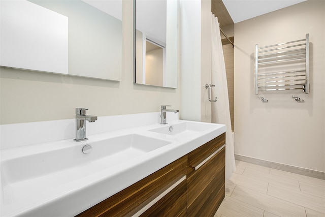 110-34 73rd Rd Unit 5A, Forest Hills, NY 11375 - bathroom featuring radiator, double vanity, shower / tub combo with curtain, and a towel warmer