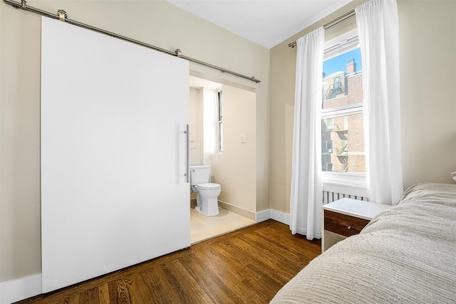 110-34 73rd Rd Unit 5A, Forest Hills, NY 11375 - bedroom featuring wood finished floors, multiple windows, a barn door, and ensuite bath