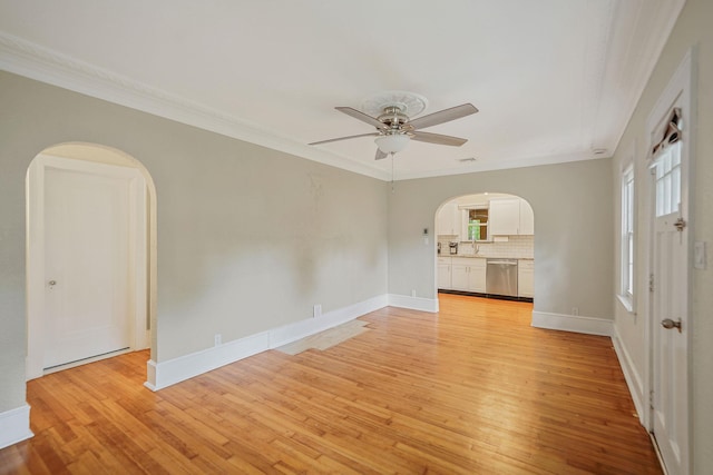 52 Mc Cue Ln, Babylon, NY 11702 - empty room featuring arched walkways, light wood finished floors, ornamental molding, and a ceiling fan