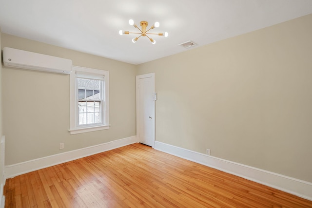52 Mc Cue Ln, Babylon, NY 11702 - unfurnished room featuring a wall unit AC, a chandelier, and light wood finished floors