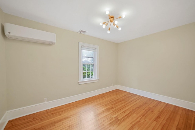 52 Mc Cue Ln, Babylon, NY 11702 - empty room featuring a chandelier, a wall unit AC, and light wood-type flooring