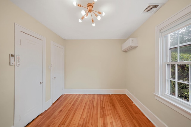 52 Mc Cue Ln, Babylon, NY 11702 - unfurnished room featuring a chandelier, an AC wall unit, healthy amount of natural light, and light wood-style floors