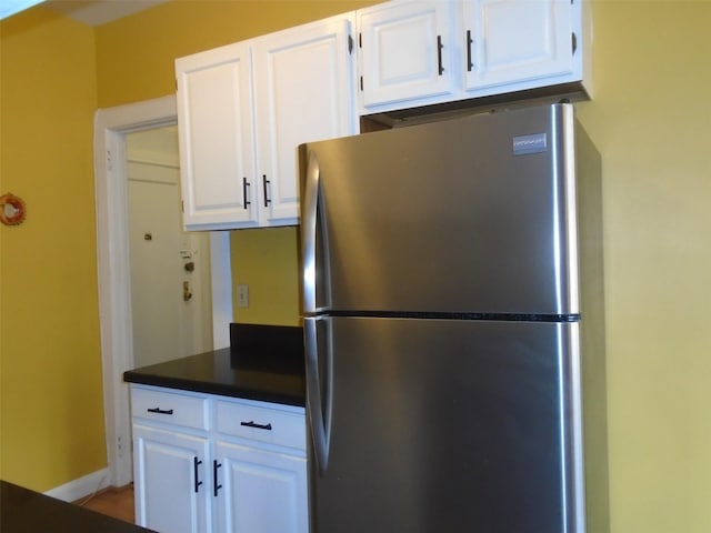 292 Main St Unit 4C, White Plains, NY 10601 - kitchen featuring freestanding refrigerator, dark countertops, and white cabinetry