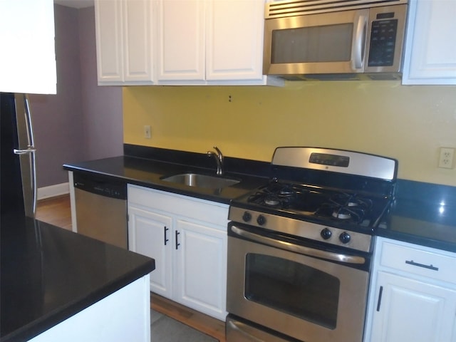 292 Main St Unit 4C, White Plains, NY 10601 - kitchen with stainless steel appliances, dark countertops, white cabinetry, and dark wood-style flooring