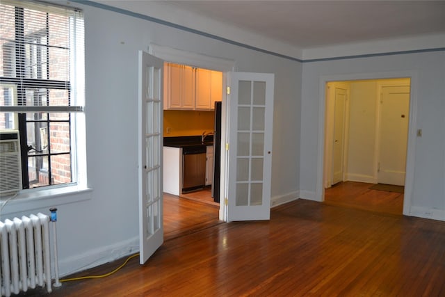 292 Main St Unit 4C, White Plains, NY 10601 - unfurnished room featuring radiator heating unit, french doors, wood finished floors, and plenty of natural light
