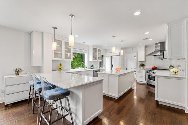 130 Carthage Rd, Scarsdale, NY 10583 - kitchen with wall chimney exhaust hood, appliances with stainless steel finishes, white cabinets, and recessed lighting