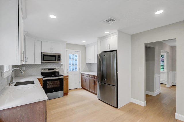 11 Henearly Dr, Miller Place, NY 11764 - kitchen featuring stainless steel appliances, light wood-style floors, backsplash, light stone counters, and recessed lighting