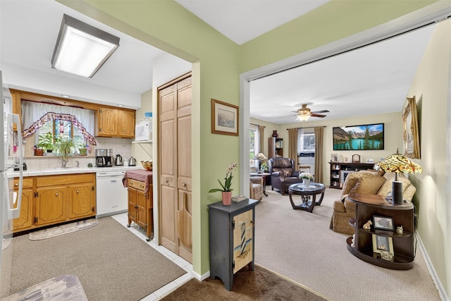 135 S Highland Ave Unit B5, Ossining, NY 10562 - kitchen featuring white dishwasher, light carpet, backsplash, open floor plan, and ceiling fan