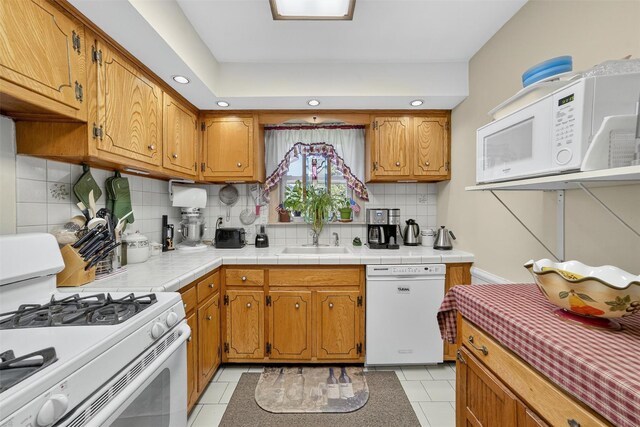135 S Highland Ave Unit B5, Ossining, NY 10562 - kitchen featuring white appliances, decorative backsplash, recessed lighting, light tile patterned floors, and brown cabinets