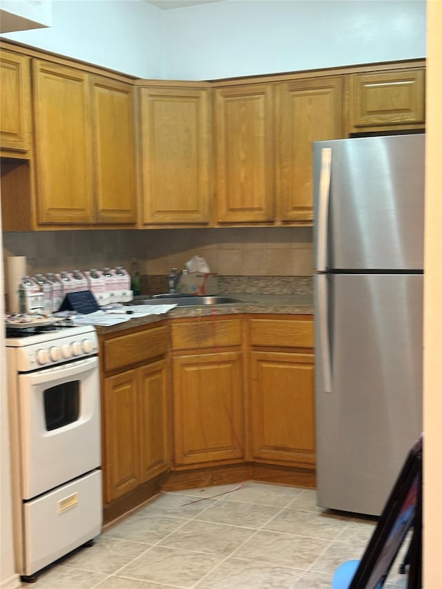 41-31 51st St Unit 6M, Woodside, NY 11377 - kitchen featuring freestanding refrigerator, white gas range oven, brown cabinets, and decorative backsplash