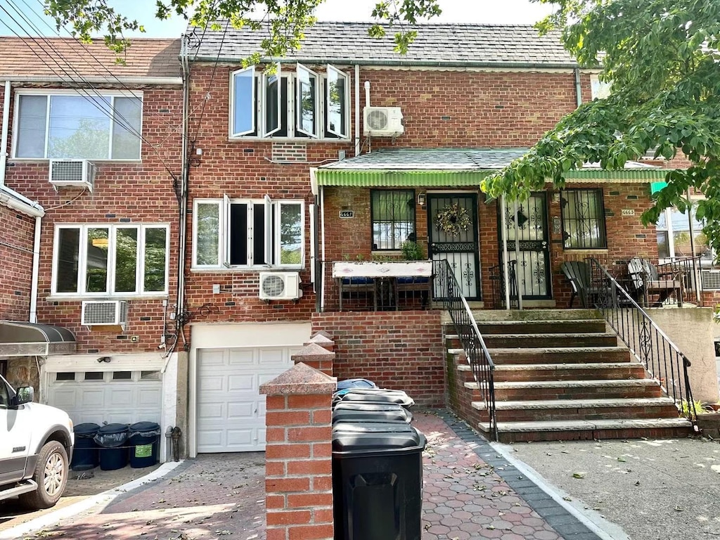 66-61 73rd Pl, Middle Village, NY 11379 - view of front facade featuring brick siding, an attached garage, and driveway