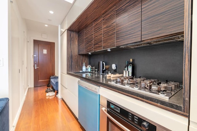 55 Wall St Unit 610, New York Manhattan, NY 10005 - indoor wet bar featuring stainless steel appliances, light wood finished floors, and recessed lighting