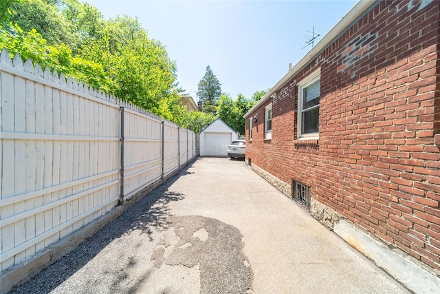 58-44 219th St, Bayside, NY 11364 - view of home's exterior featuring brick siding, an outbuilding, a detached garage, and driveway