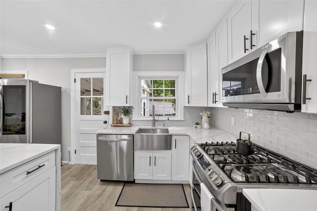 130 Cresthill Rd, Yonkers, NY 10710 - kitchen with appliances with stainless steel finishes, tasteful backsplash, white cabinetry, light wood-style floors, and light stone counters