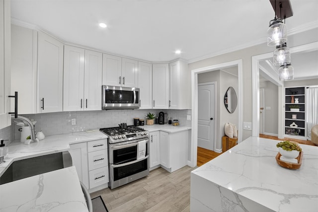 130 Cresthill Rd, Yonkers, NY 10710 - kitchen with stainless steel appliances, light wood-type flooring, white cabinets, decorative backsplash, and pendant lighting