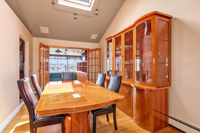 3337 Murdock Ave, Oceanside, NY 11572 - dining space with french doors, a baseboard radiator, light wood-style floors, a skylight, and vaulted ceiling