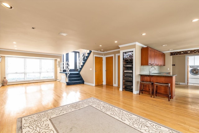3337 Murdock Ave, Oceanside, NY 11572 - unfurnished living room with ornamental molding, washer / dryer, healthy amount of natural light, light wood-type flooring, and recessed lighting