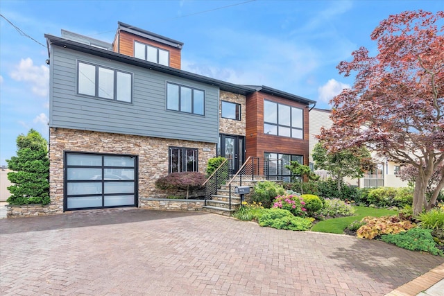 3337 Murdock Ave, Oceanside, NY 11572 - contemporary home with stone siding, an attached garage, and asphalt driveway