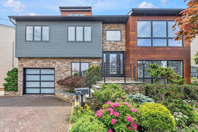 3337 Murdock Ave, Oceanside, NY 11572 - modern home with stone siding, a garage, and decorative driveway