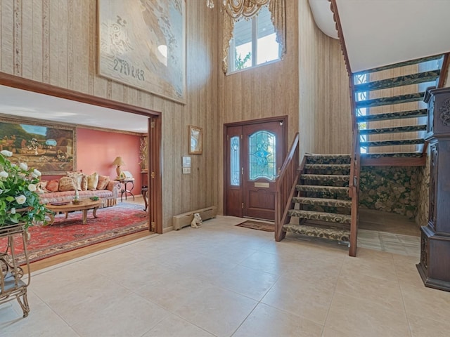 2000 Lake End Rd, Merrick, NY 11566 - foyer entrance with stairway, a high ceiling, tile patterned flooring, a chandelier, and wooden walls