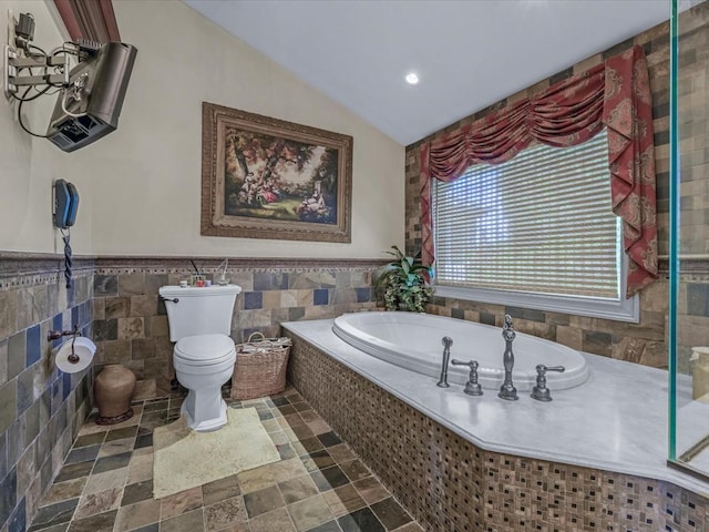 2000 Lake End Rd, Merrick, NY 11566 - bathroom with tile walls, a bath, stone finish flooring, lofted ceiling, and a wainscoted wall