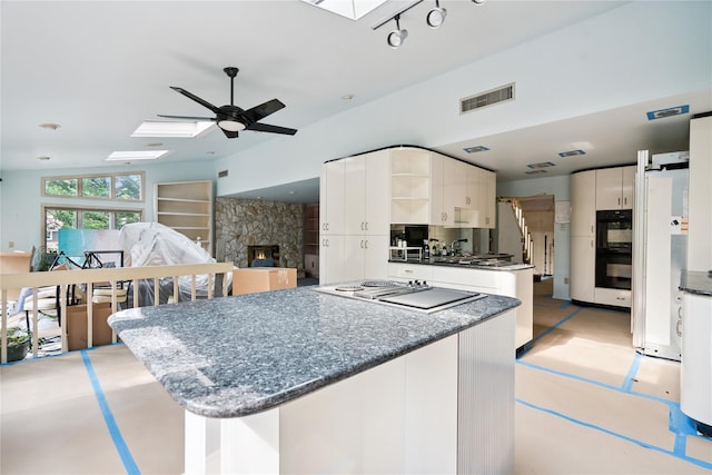 35 Stratford Ave, Dix Hills, NY 11746 - kitchen with a skylight, stainless steel electric stovetop, freestanding refrigerator, ceiling fan, and open shelves