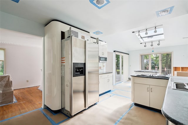 35 Stratford Ave, Dix Hills, NY 11746 - kitchen featuring appliances with stainless steel finishes, white cabinetry, track lighting, lofted ceiling, and light wood-type flooring