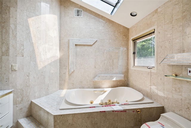 35 Stratford Ave, Dix Hills, NY 11746 - bathroom featuring tile walls, a skylight, a jetted tub, and lofted ceiling