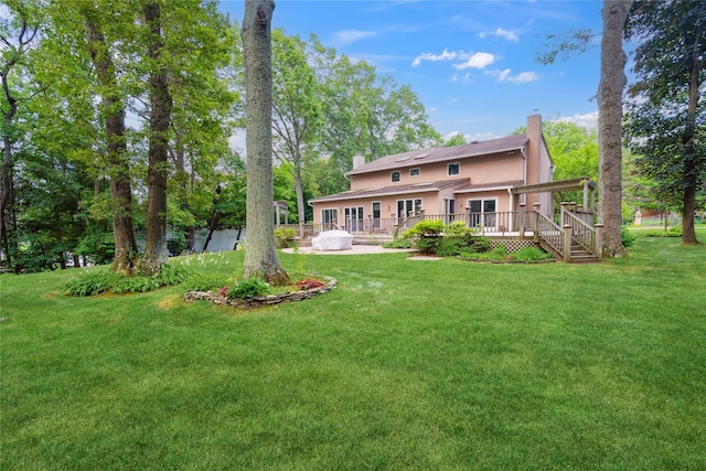 35 Stratford Ave, Dix Hills, NY 11746 - back of house featuring a chimney, a wooden deck, and a lawn