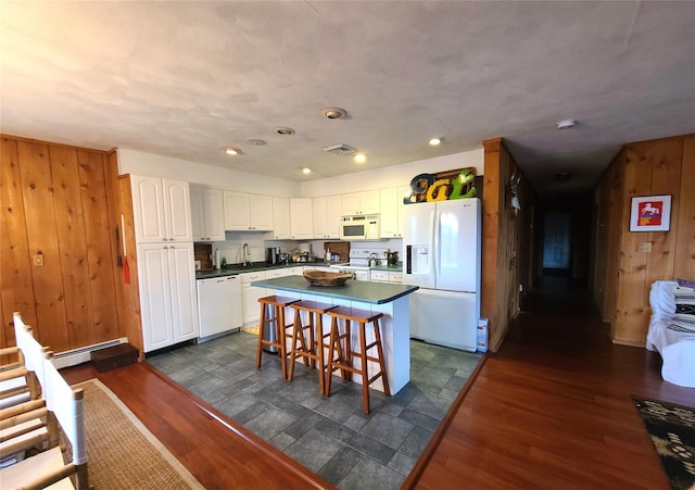 282 W Shore Rd, Swan Lake, NY 12783 - kitchen with white appliances, wooden walls, dark countertops, white cabinetry, and a kitchen island