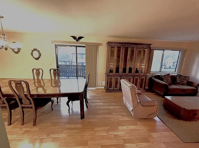108 Village Rd Unit B, Jefferson Valley, NY 10598 - dining space featuring light wood-type flooring and a chandelier