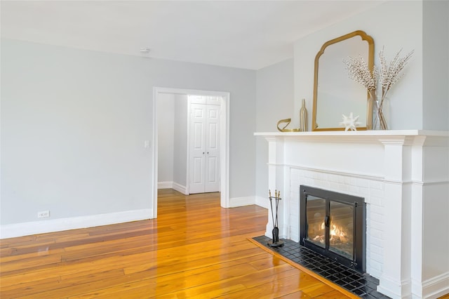 914 Wynnewood Rd Unit 3R, Pelham, NY 10803 - unfurnished living room with wood-type flooring and a brick fireplace
