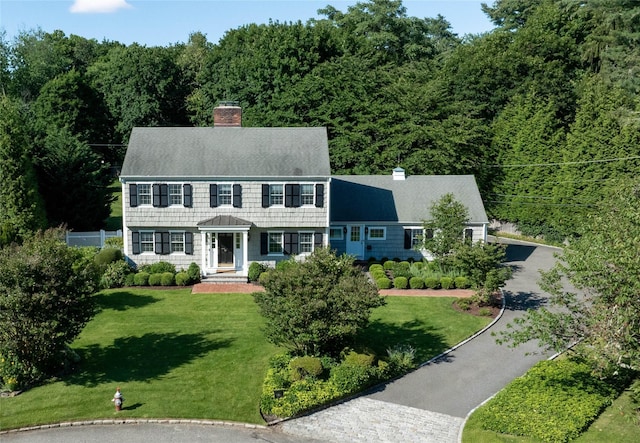 6 Meadow Pl, Lattingtown, NY 11560 - view of front of house featuring a chimney, a wooded view, and a front lawn