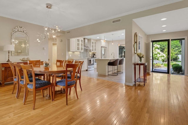 623 Heritage Hls Unit B, Somers, NY 10589 - dining room featuring light wood-style floors, ornamental molding, and a chandelier