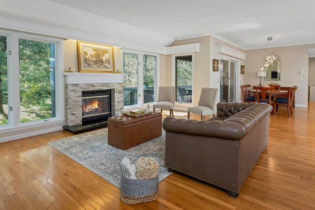 623 Heritage Hls Unit B, Somers, NY 10589 - living room featuring crown molding, light wood-style flooring, a stone fireplace, and a chandelier