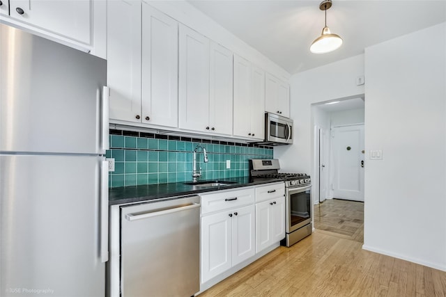 48-55 43rd St Unit 4H, Woodside, NY 11377 - kitchen featuring appliances with stainless steel finishes, dark countertops, backsplash, and white cabinets