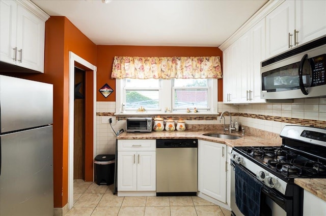 10719 Sutter Ave, Ozone Park, NY 11417 - kitchen featuring appliances with stainless steel finishes, white cabinets, and light tile patterned flooring