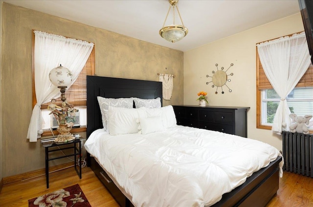 10719 Sutter Ave, Ozone Park, NY 11417 - bedroom featuring radiator heating unit and wood finished floors