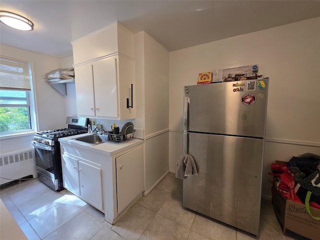 1234MIDLAND Ave Ave Unit 1C, Bronxville, NY 10708 - kitchen with stainless steel appliances, radiator, light countertops, white cabinetry, and light tile patterned floors