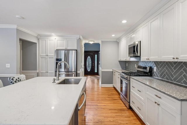 5 Aspen Cir, Saint James, NY 11780 - kitchen featuring stainless steel appliances, light wood-type flooring, tasteful backsplash, ornamental molding, and white cabinets