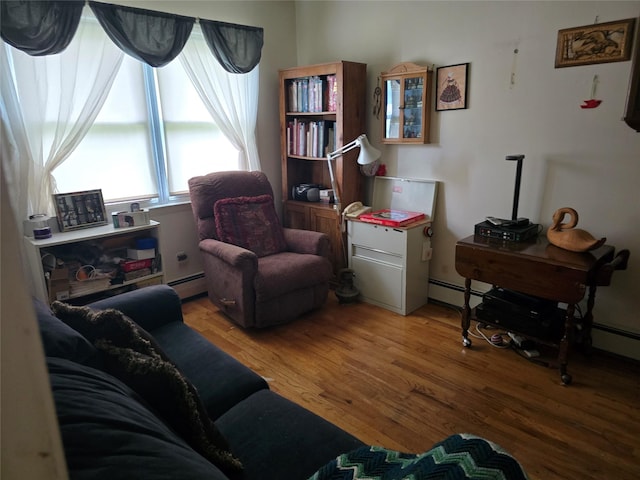 27 Leo Ln, Deer Park, NY 11729 - living area with a baseboard heating unit and wood finished floors