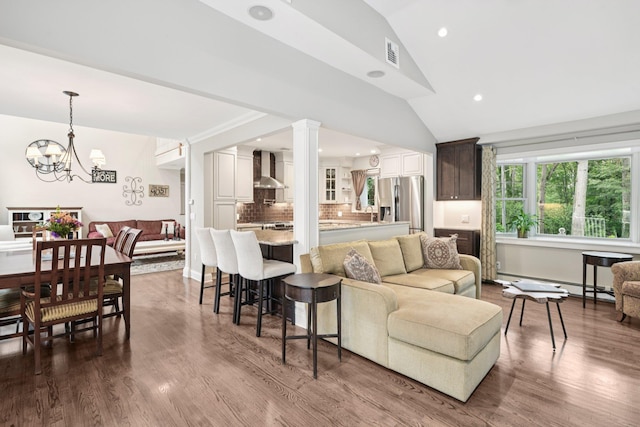 23 Alpine Way S, Huntington, NY 11746 - living room featuring a baseboard radiator, lofted ceiling, a chandelier, recessed lighting, and dark wood-style floors