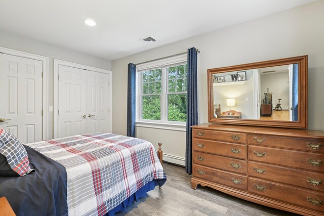 23 Alpine Way S, Huntington, NY 11746 - bedroom with wood finished floors, recessed lighting, a baseboard heating unit, and a closet