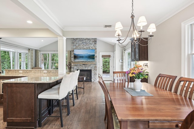 23 Alpine Way S, Huntington, NY 11746 - dining area featuring lofted ceiling, a chandelier, wood finished floors, crown molding, and a stone fireplace