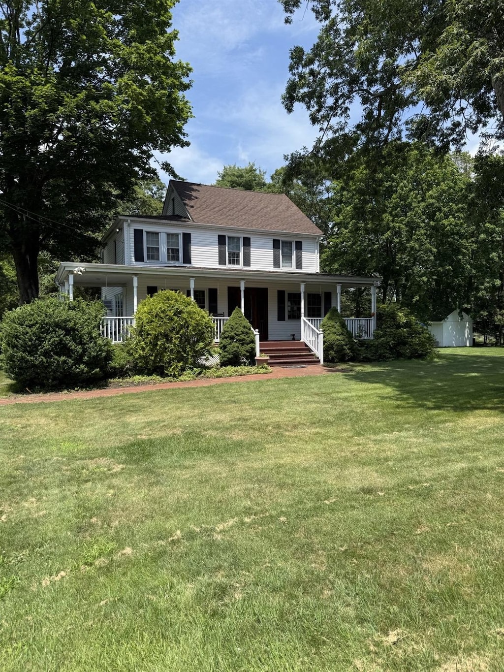 1 Garfield Ct, Nesconset, NY 11767 - farmhouse-style home featuring covered porch, a front yard, and an outbuilding