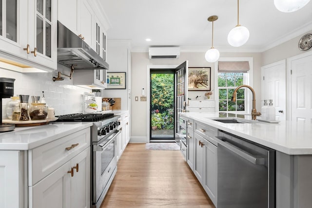 90-01 68th Ave, Forest Hills, NY 11375 - kitchen with stainless steel appliances, under cabinet range hood, a wall mounted air conditioner, light countertops, and crown molding